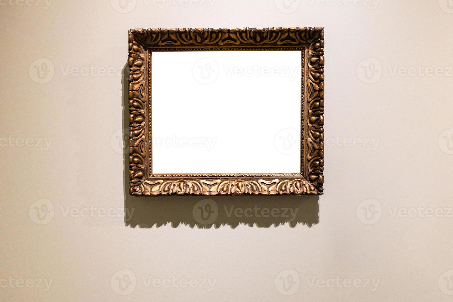 old carved wide bronze picture frame on brown wall photo