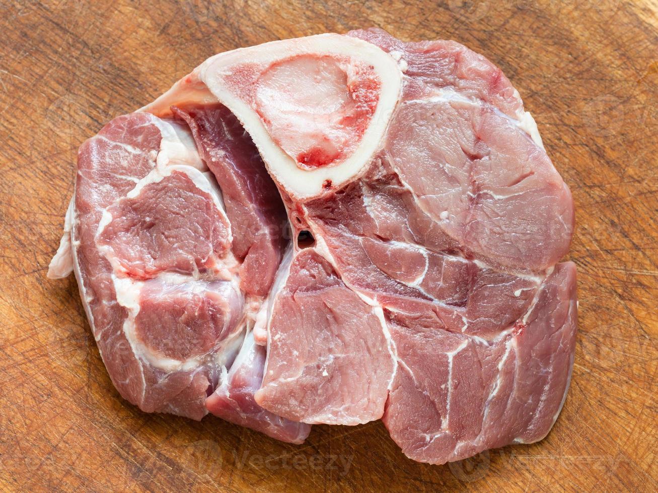 raw veal meat with marrowbone on wooden board photo