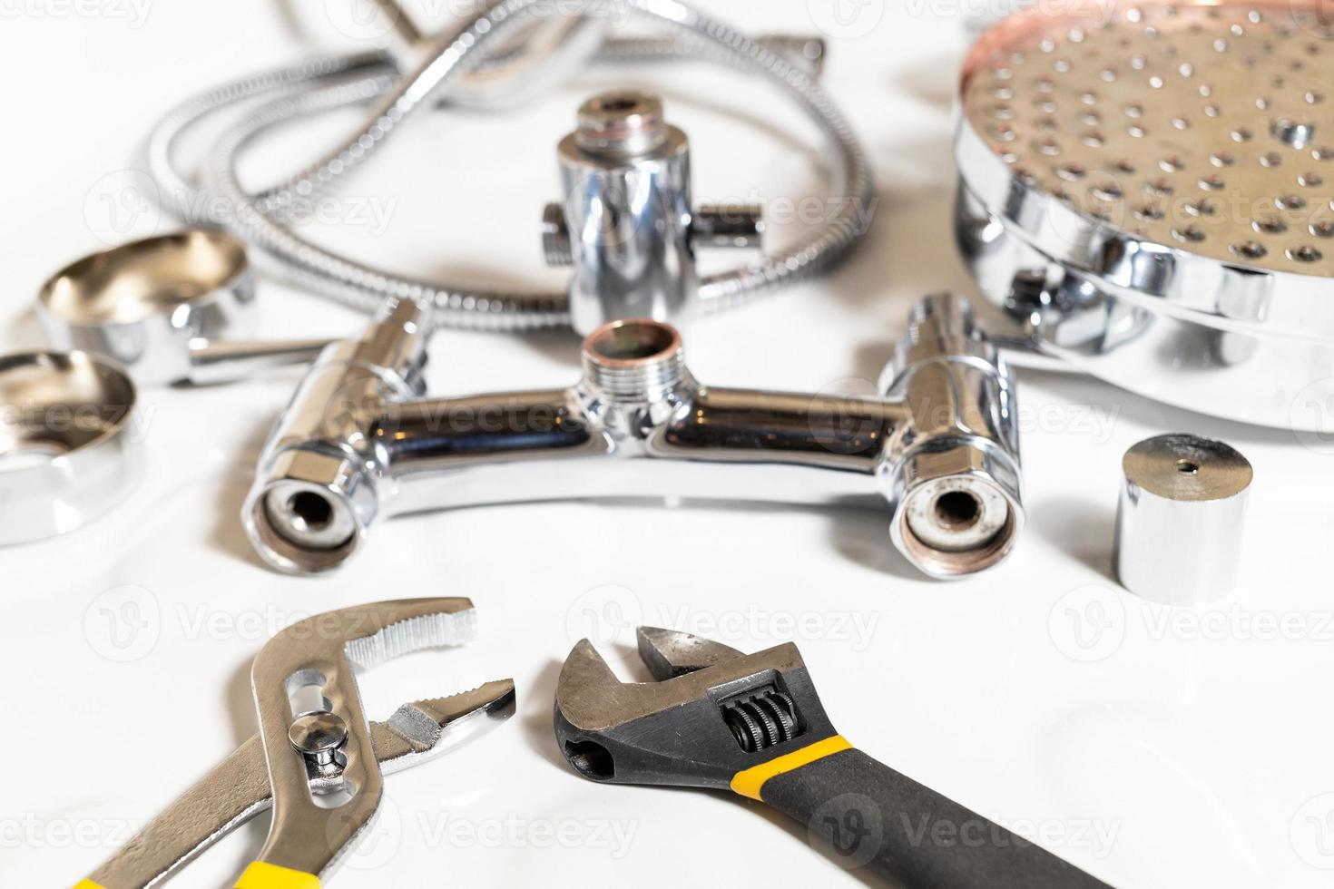 wrenches closeup and disassembled shower faucet photo