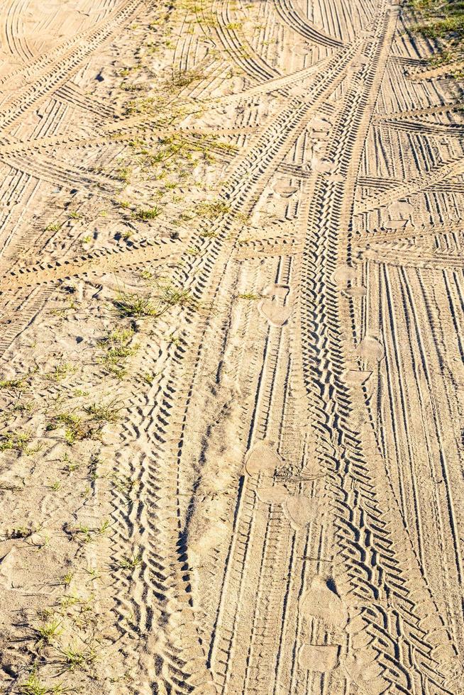 traces and footprints on surface of dirty road photo