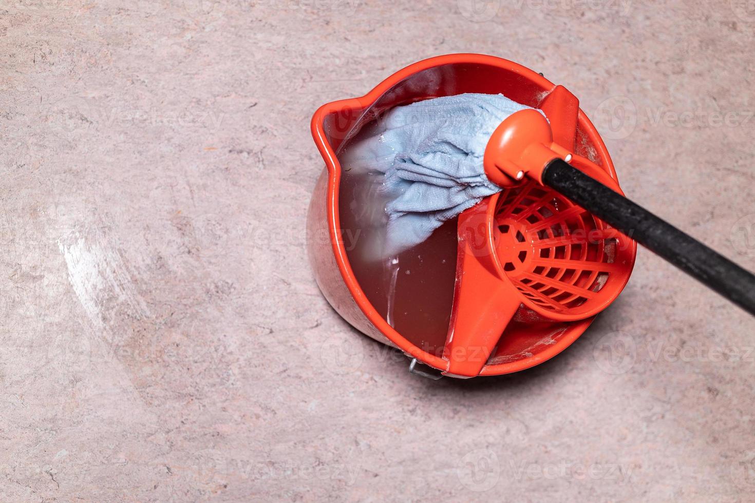 top view of mop in red bucket with dirty water photo