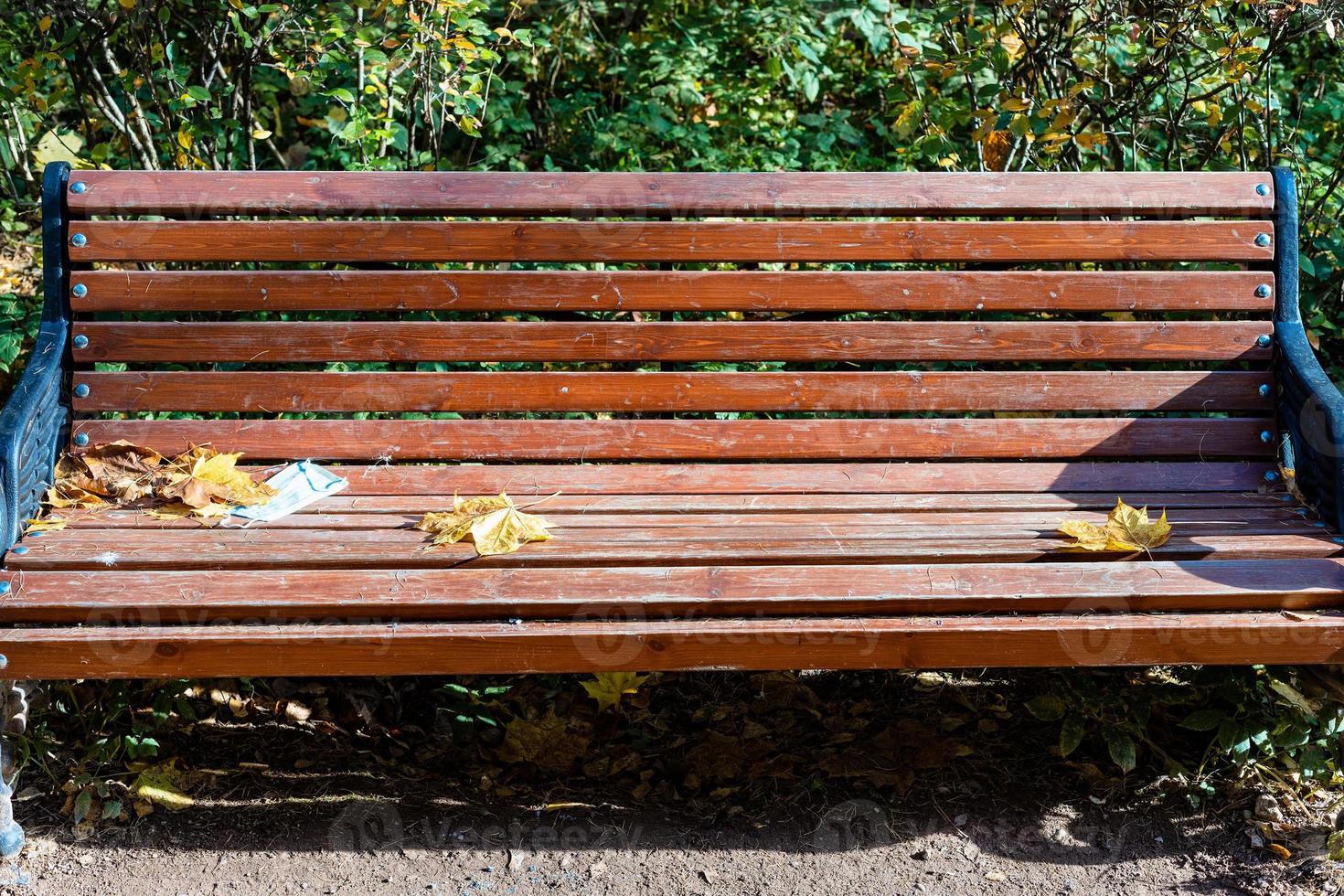 front view of wooden bench with used face mask photo