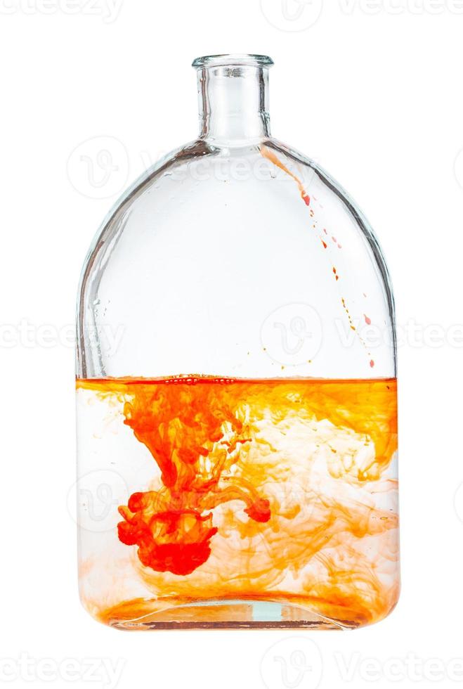 orange watercolour paint dissolves in glass flask photo