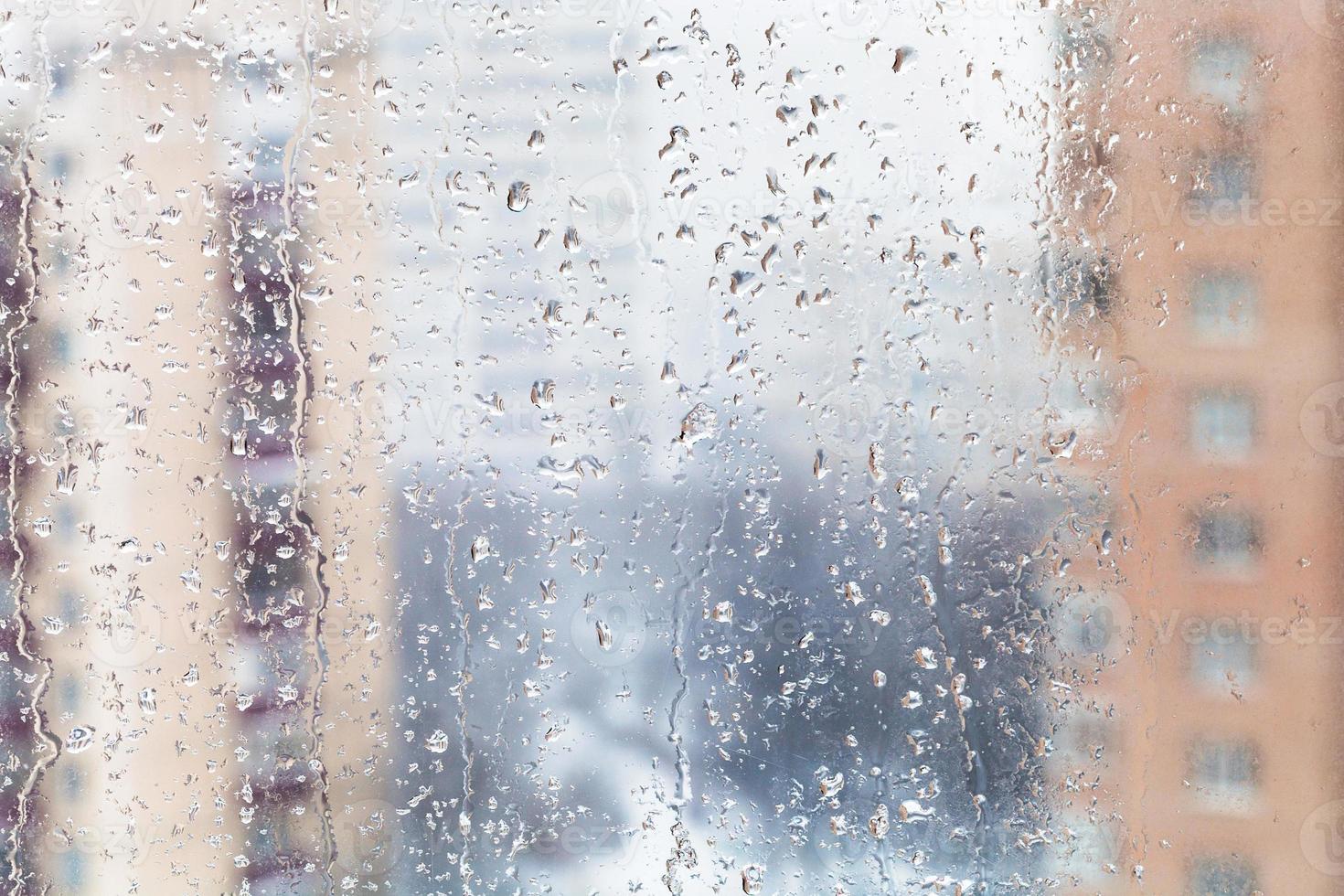rain drops on home window glass in winter photo