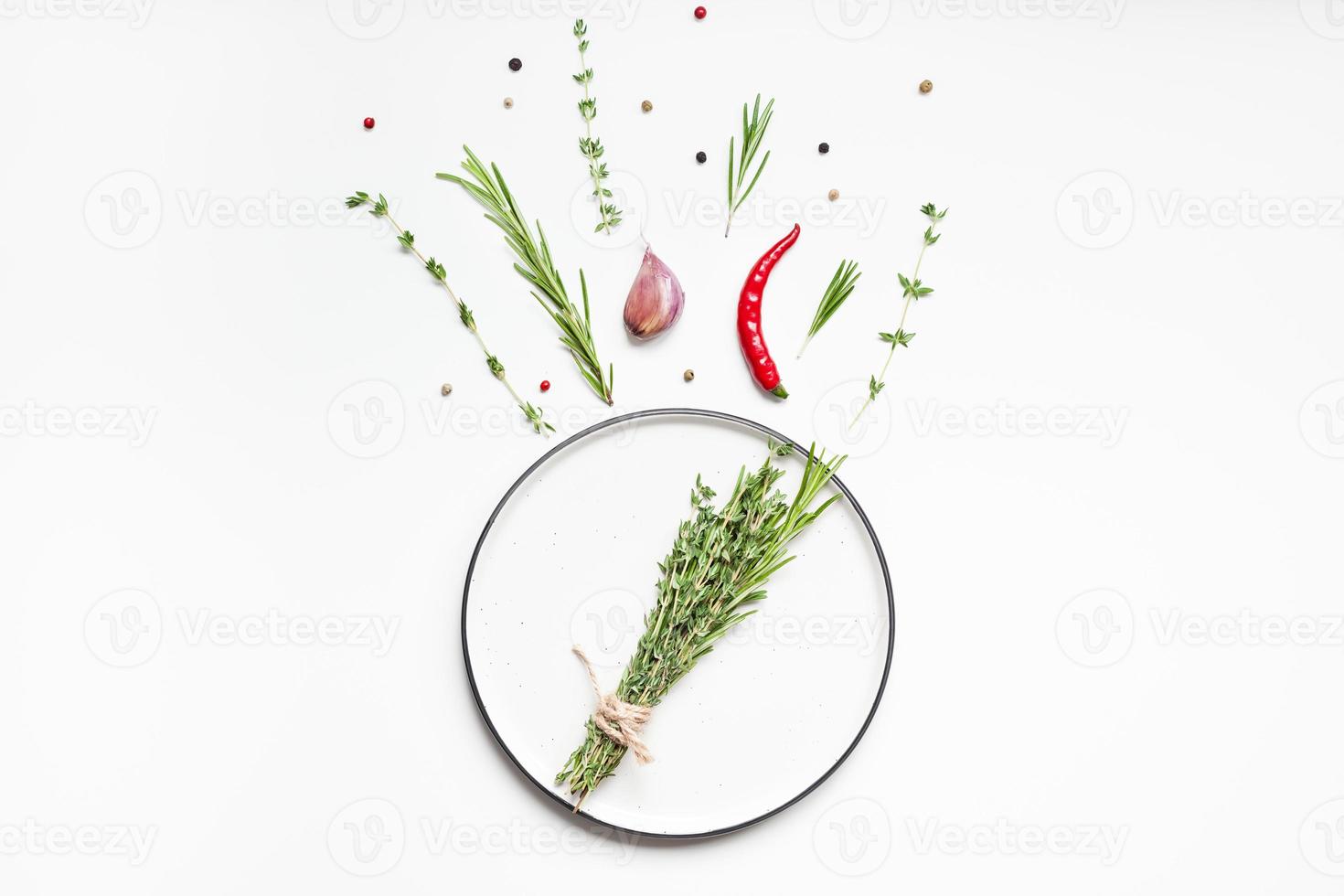 Empty plate with greens herbs and spices around photo