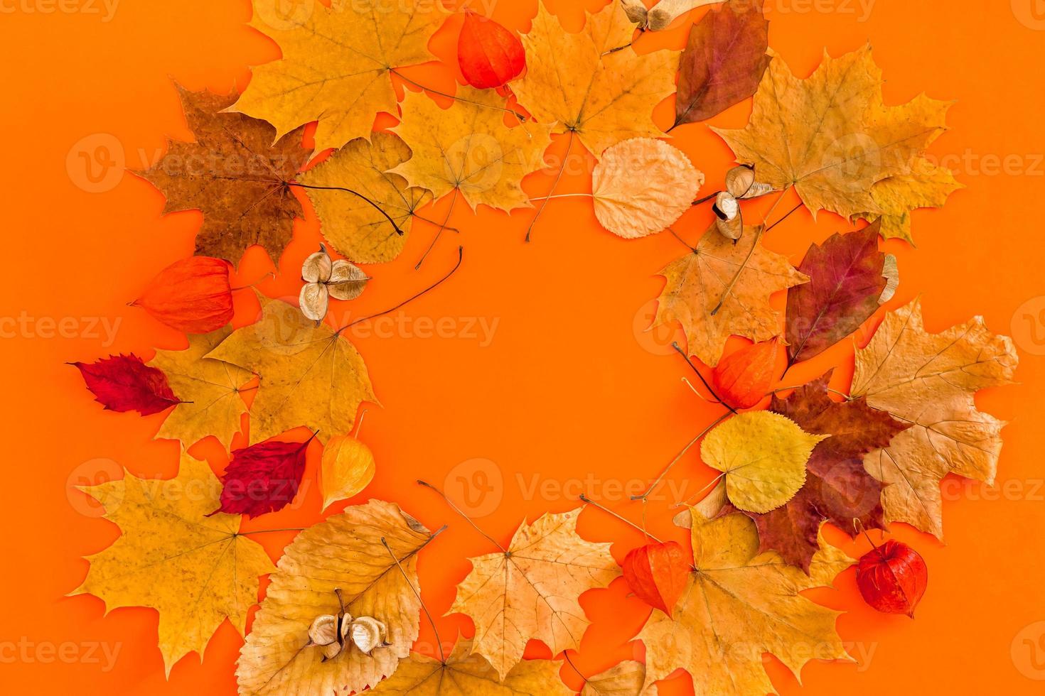 marco de corona de hojas secas sobre fondo de color naranja foto