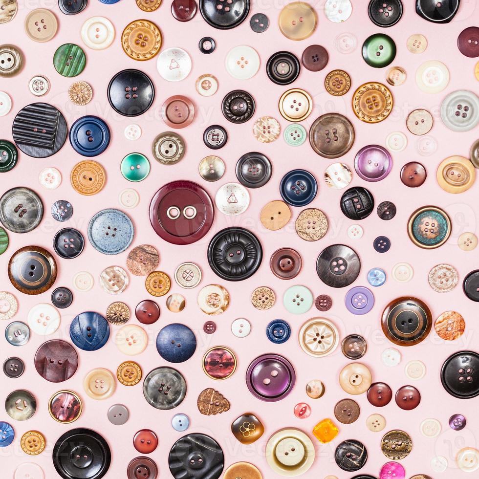 many various buttons on pink background photo