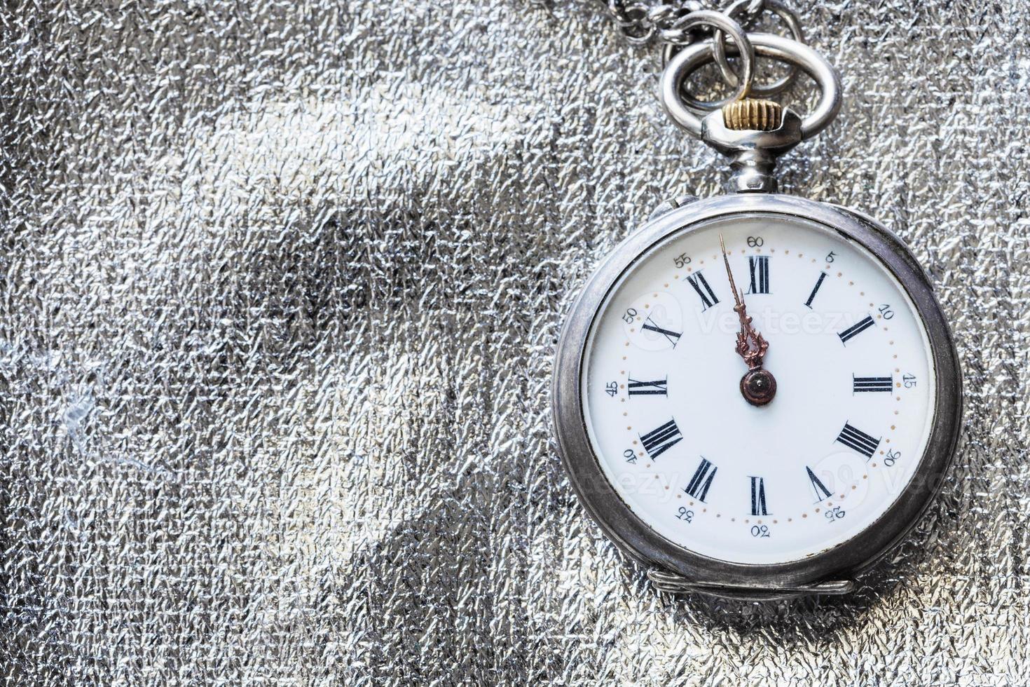 antique pocket watch on silver textile background photo