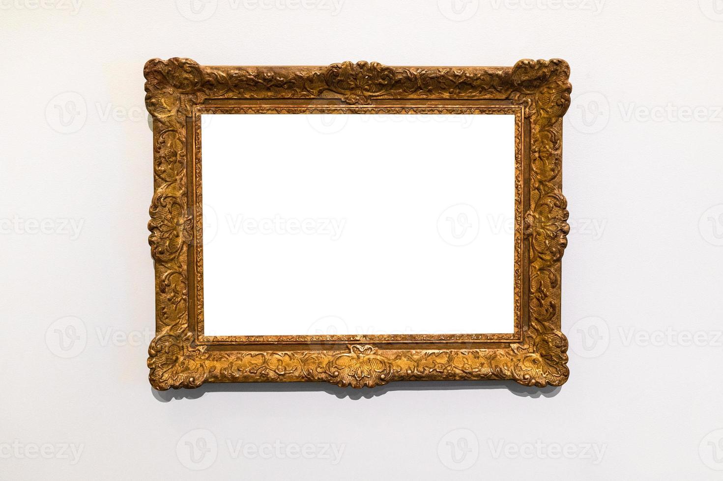 old decorated wide gold picture frame on gray wall photo