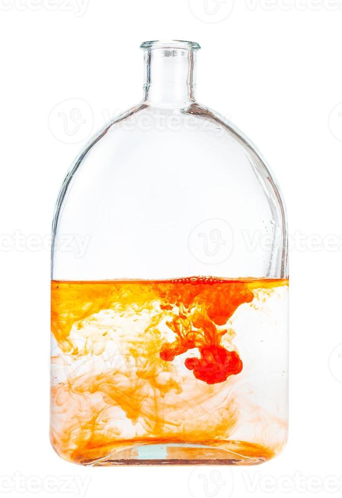 orange watercolors dissolving in water in flask photo