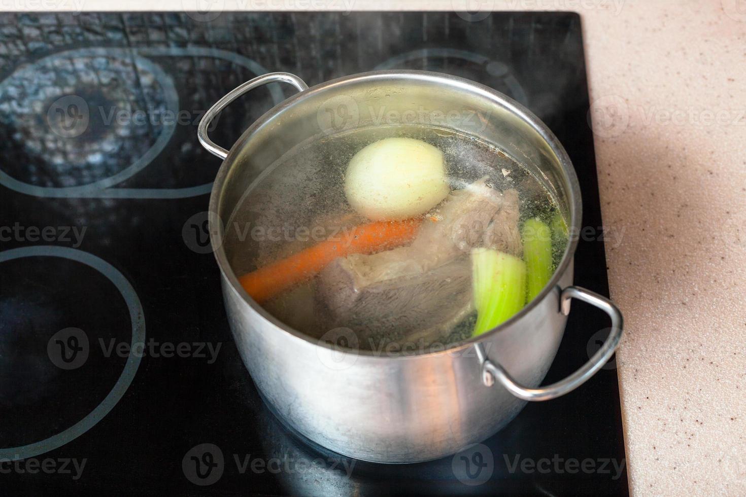 preparing meat broth in stockpot on ceramic cooker photo