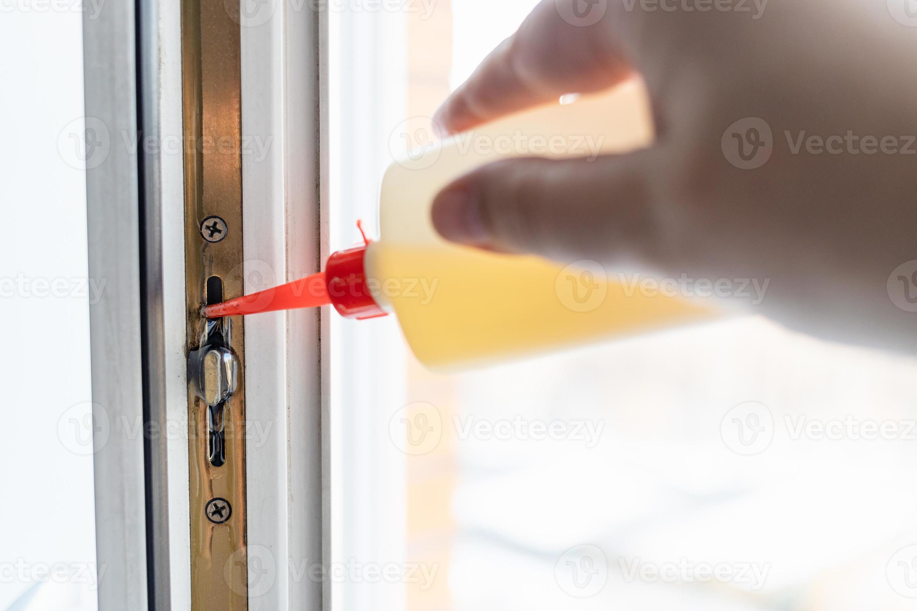 lubricating window frame mechanism with oil f 11185496 Stock Photo at