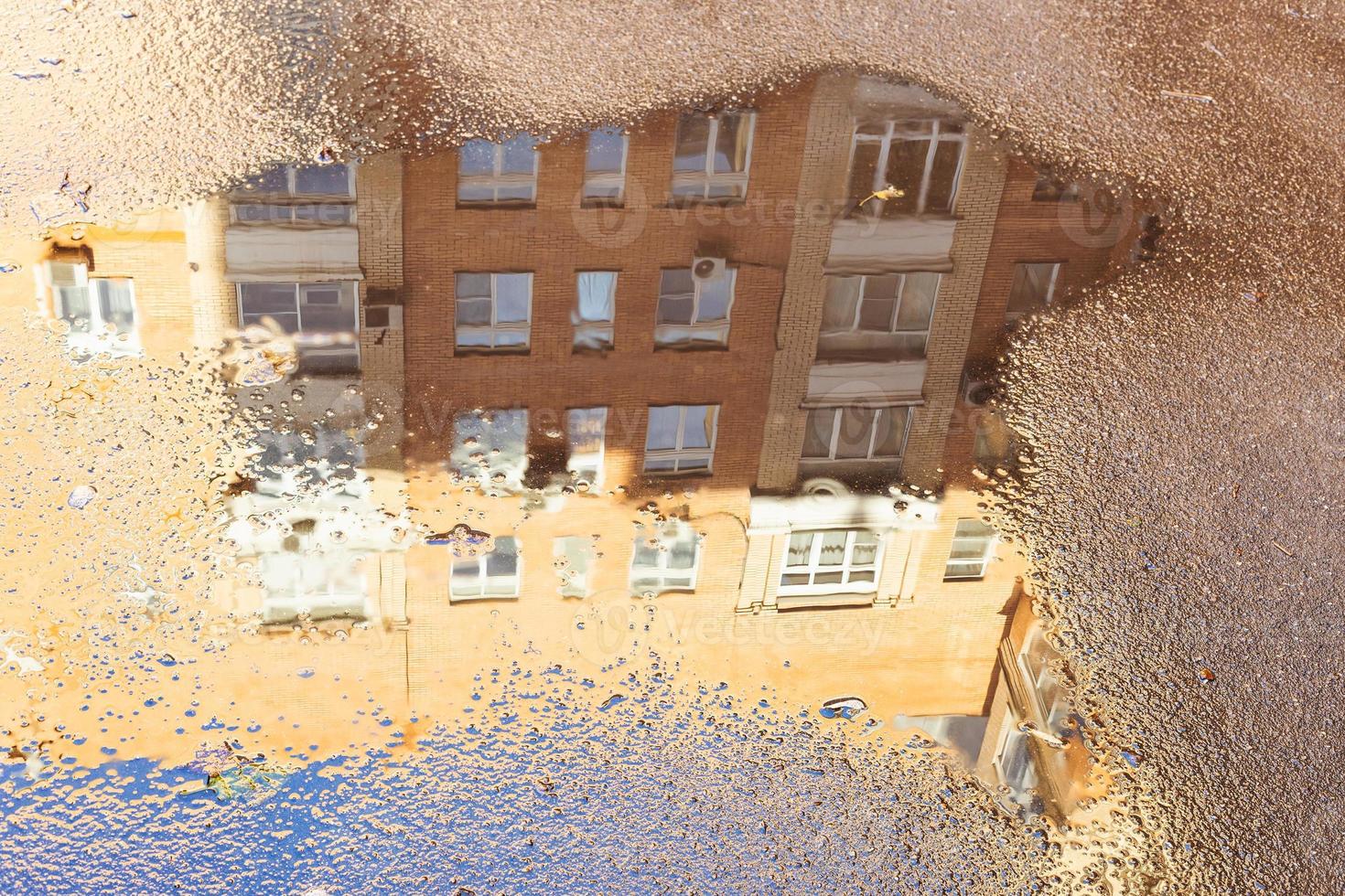 puddle with reflection of apartment house photo
