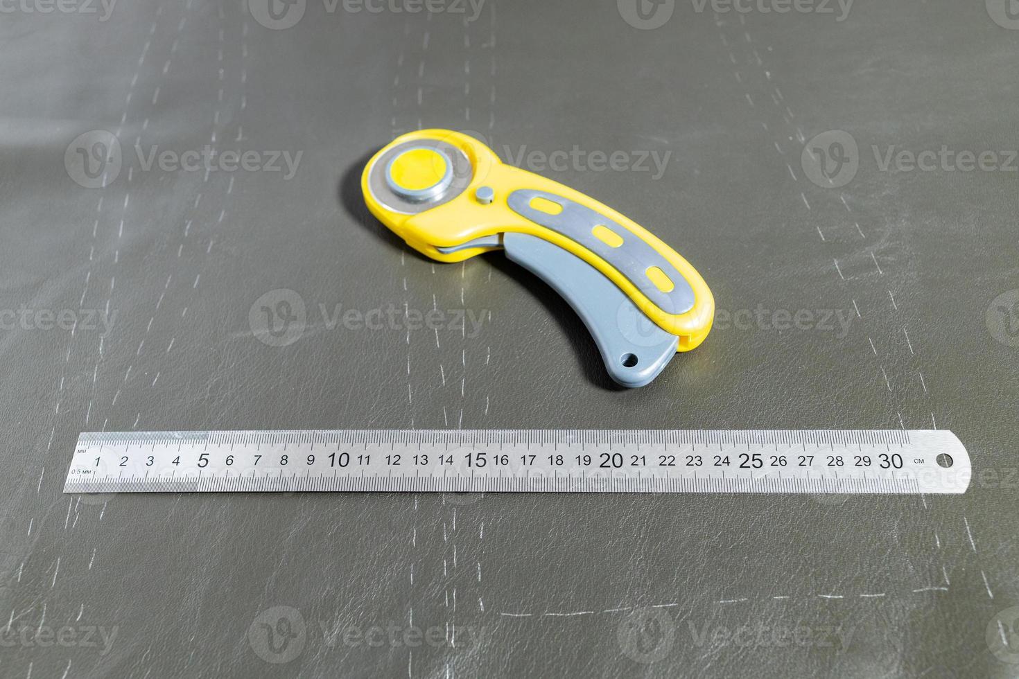 steel ruler and rotary cutter on leather photo