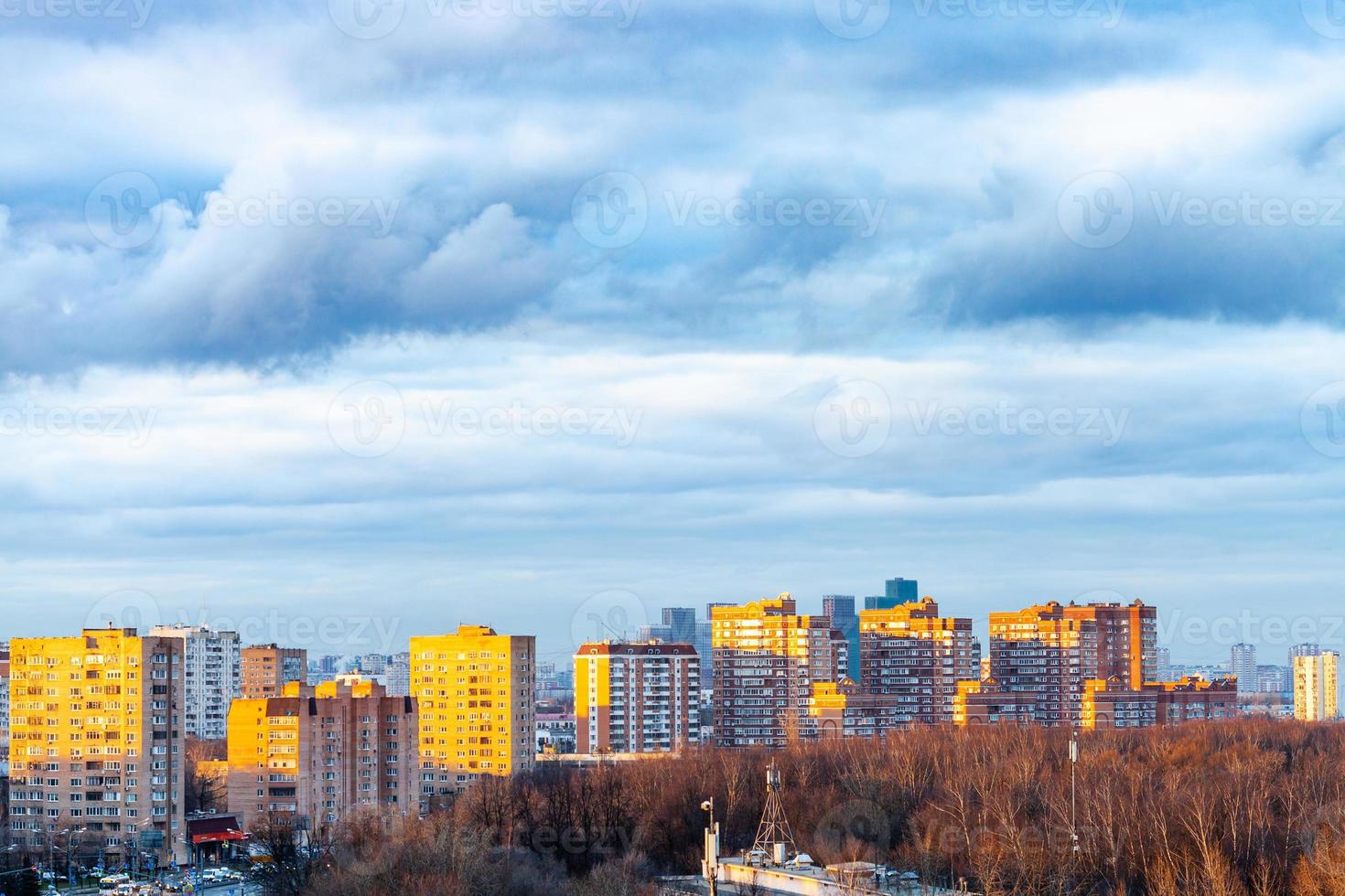 dark blue clouds over buildings in spring evening photo