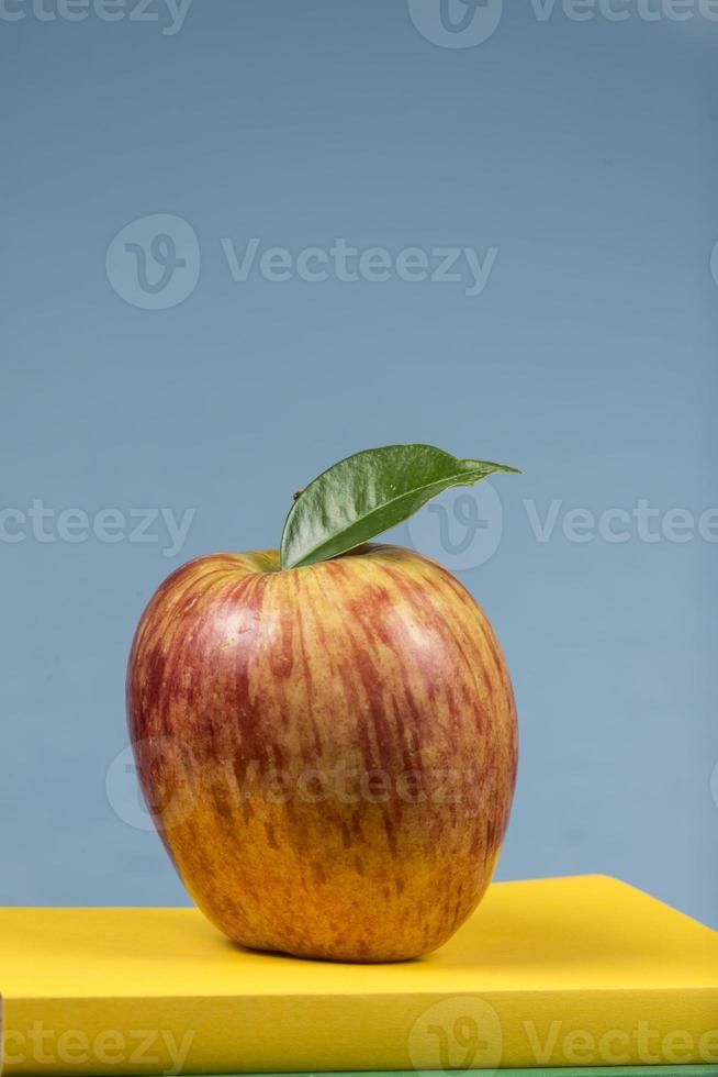 fruta de manzana encima de una pila de libros, en la parte posterior de las clases escolares. foto