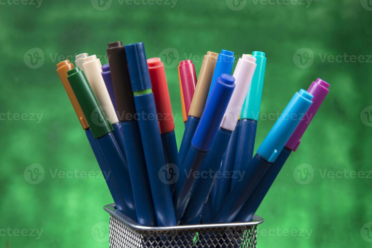 Creativity of Colorful Colored Pen in Pencil Case with Copy Space on Blurred Bokeh green Background photo