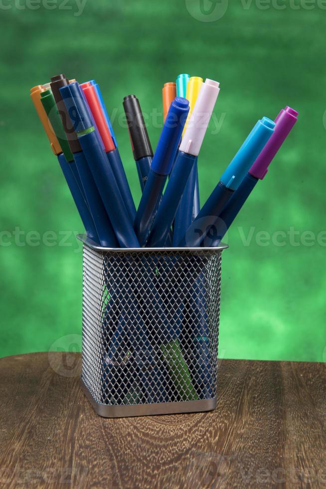Creativity of Colorful Colored Pen in Pencil Case with Copy Space on Blurred Bokeh green Background photo