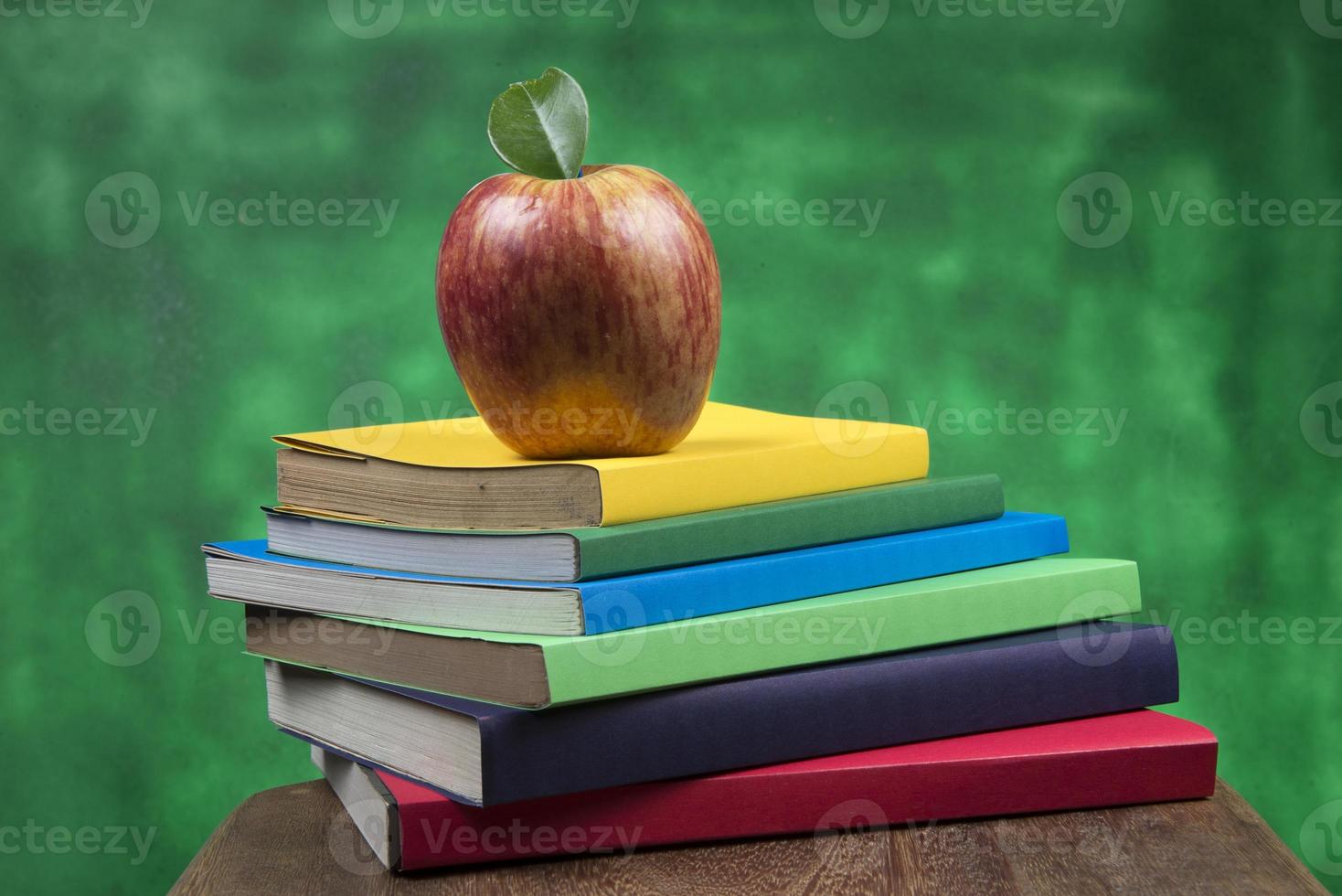 Apple fruit on top of a book stack, on the back of school classes. photo