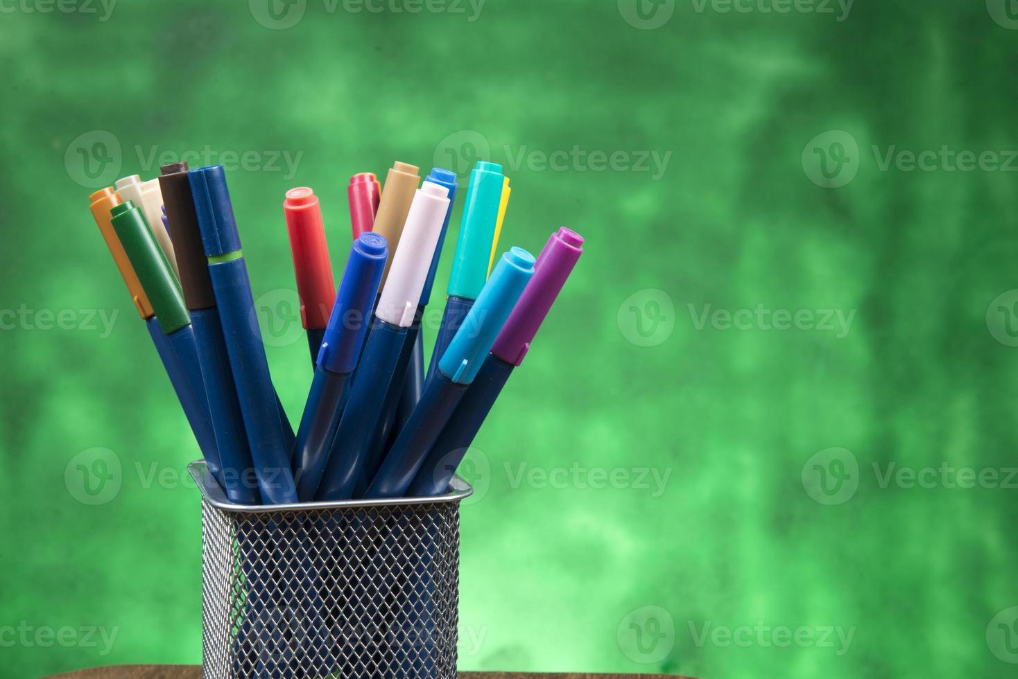 Creativity of Colorful Colored Pen in Pencil Case with Copy Space on Blurred Bokeh green Background photo