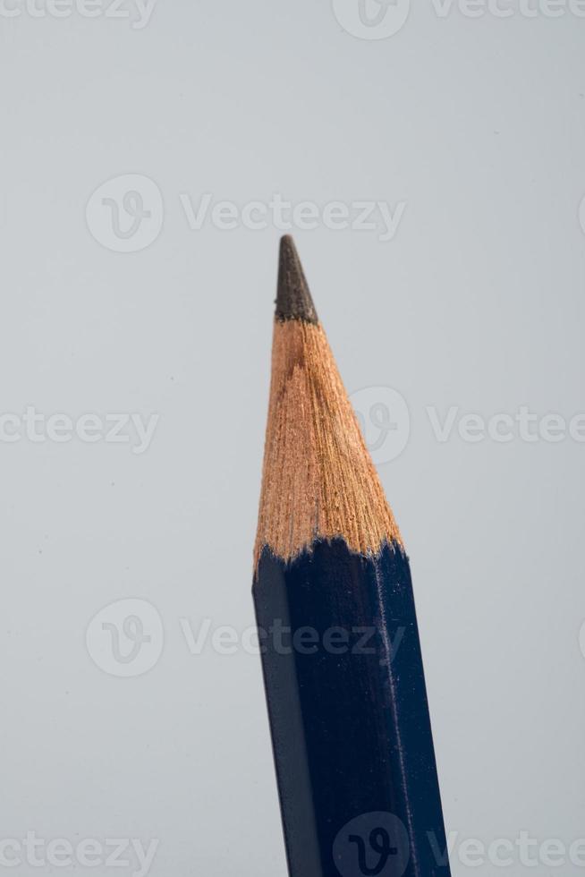 detalle de punta de lápices negros sobre un pequeño fondo azul foto