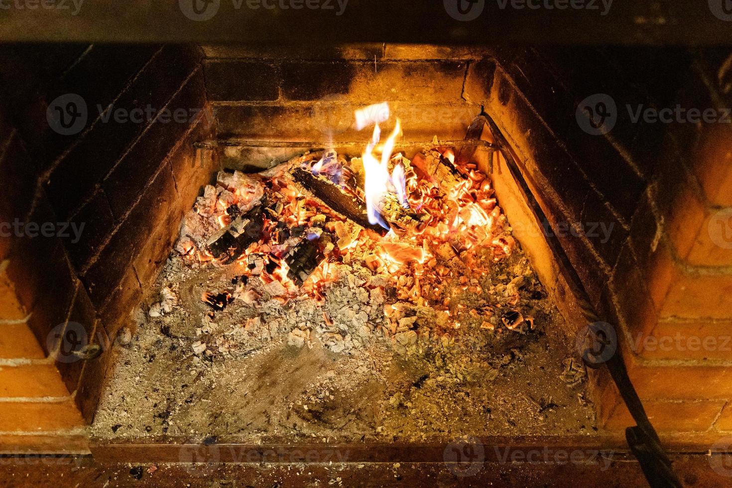 smoldering firewood and ash in home fireplace photo