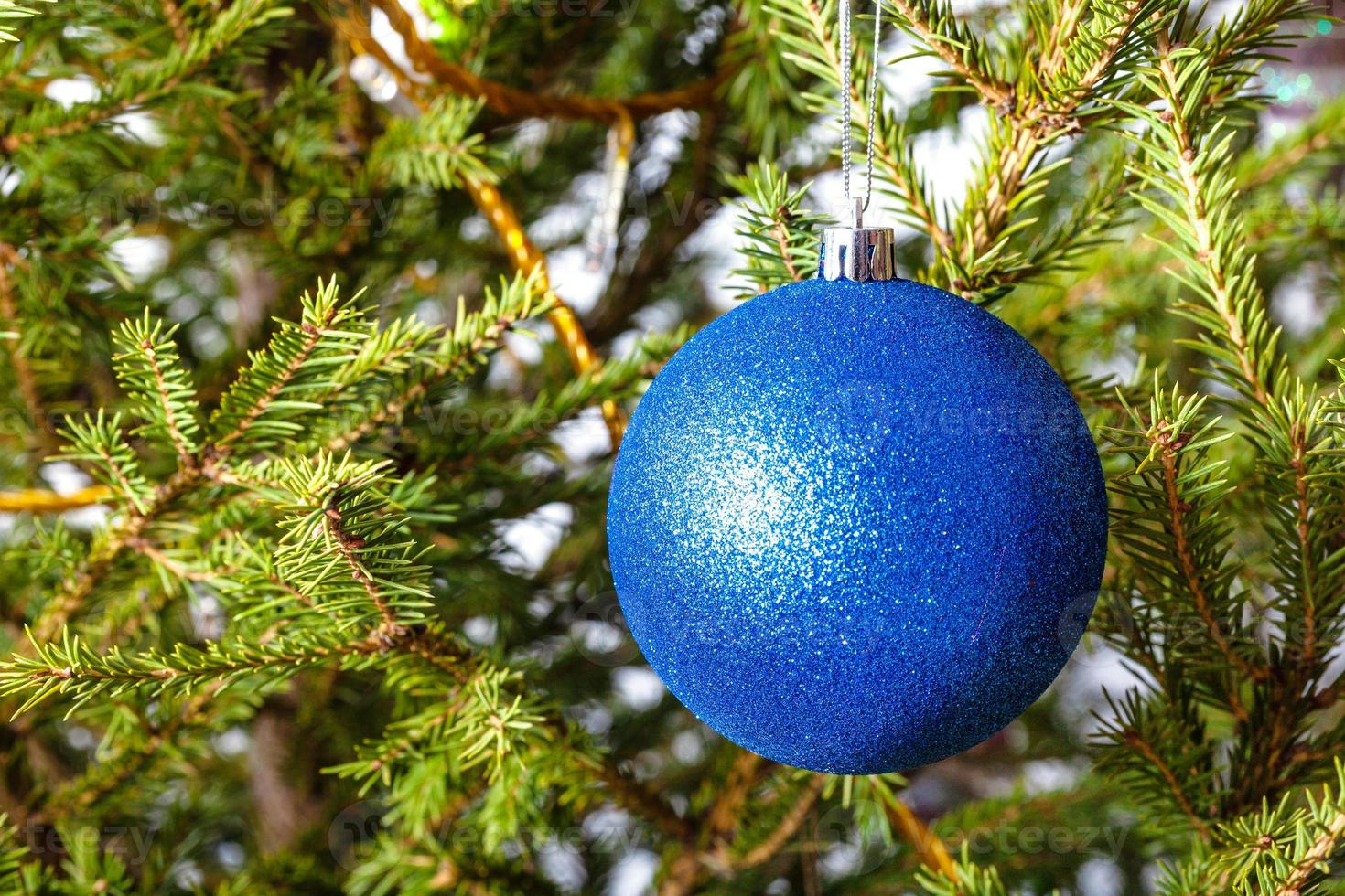 bola azul en ramitas de árbol de navidad natural foto