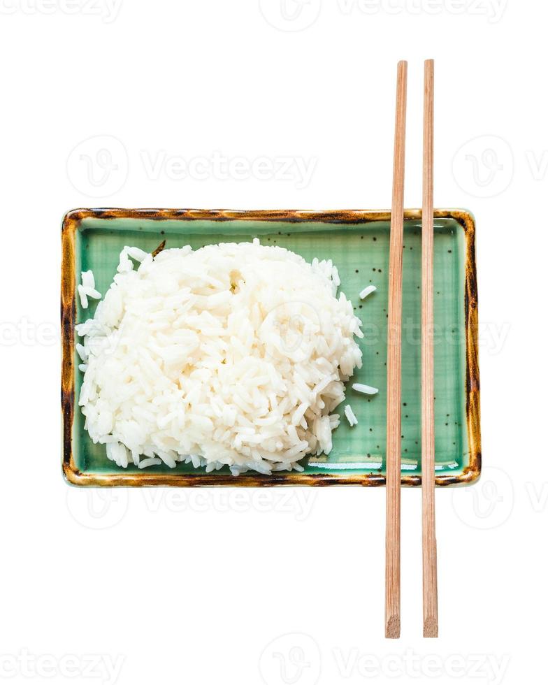 boiled rice and chopsticks on green plate isolated photo