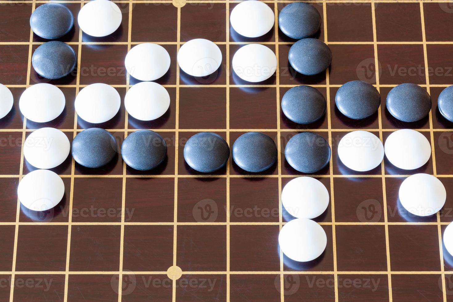 gameplay of Go game on wooden board photo