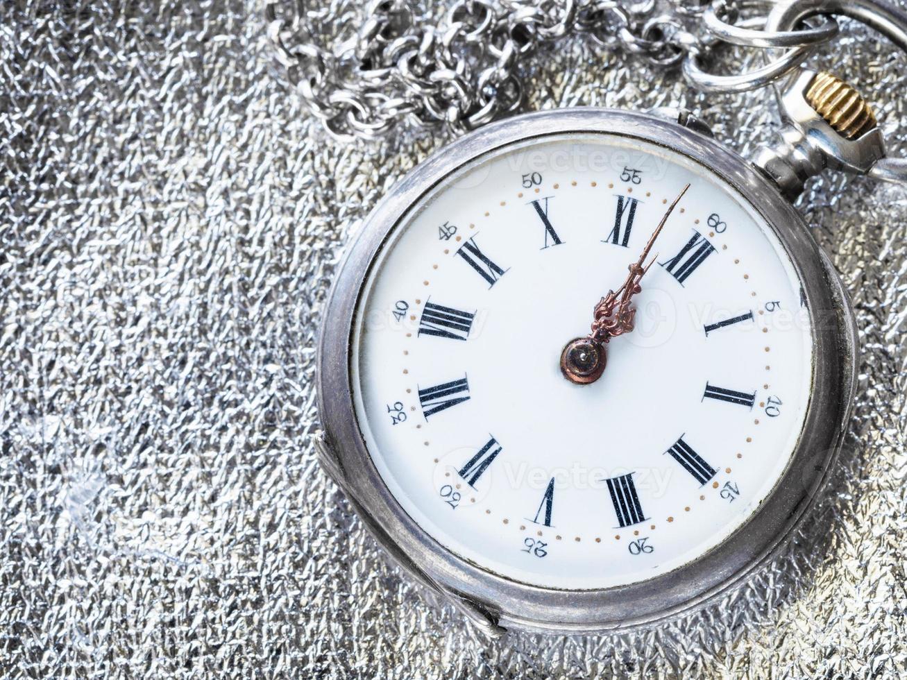 antique pocket watch on silver fabric close up photo