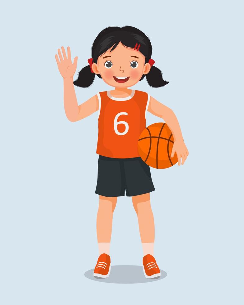 linda niña con ropa deportiva sosteniendo baloncesto de pie posando con saludo y saludando con la mano vector