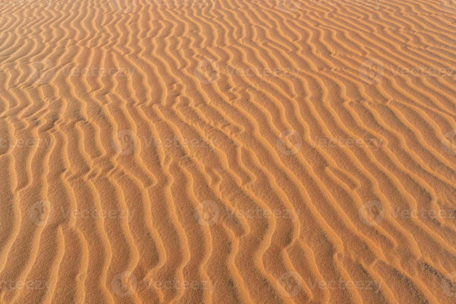 Abstract background and texture of sand waves in desert photo