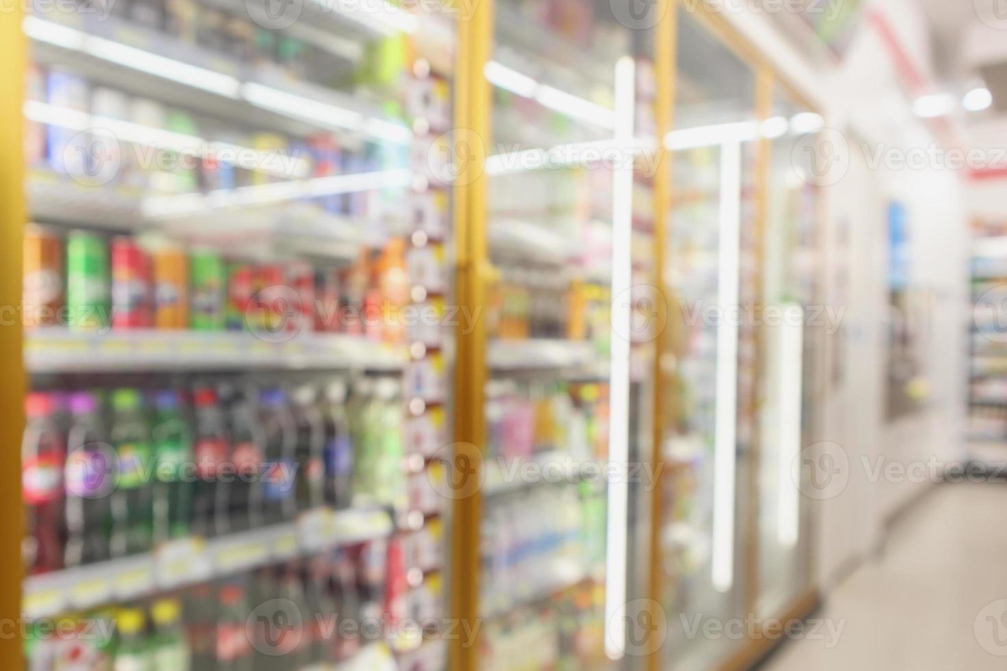 Beverage soft drink bottles in convenience store refrigerator shelves blurred background photo