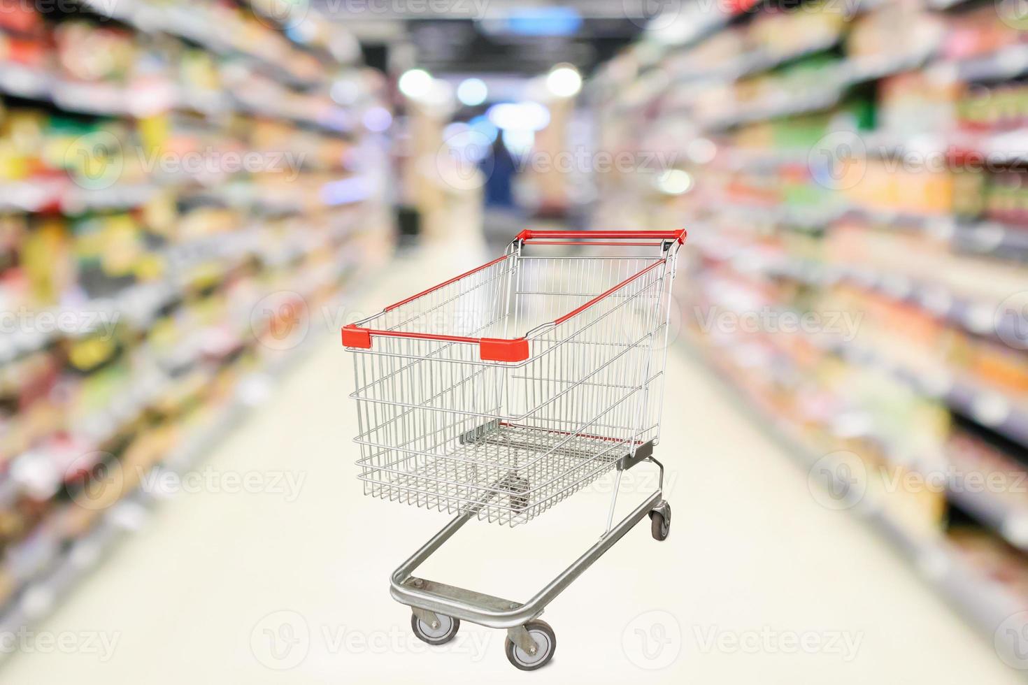 Empty shopping cart with abstract blur supermarket discount store aisle and product shelves interior defocused background photo