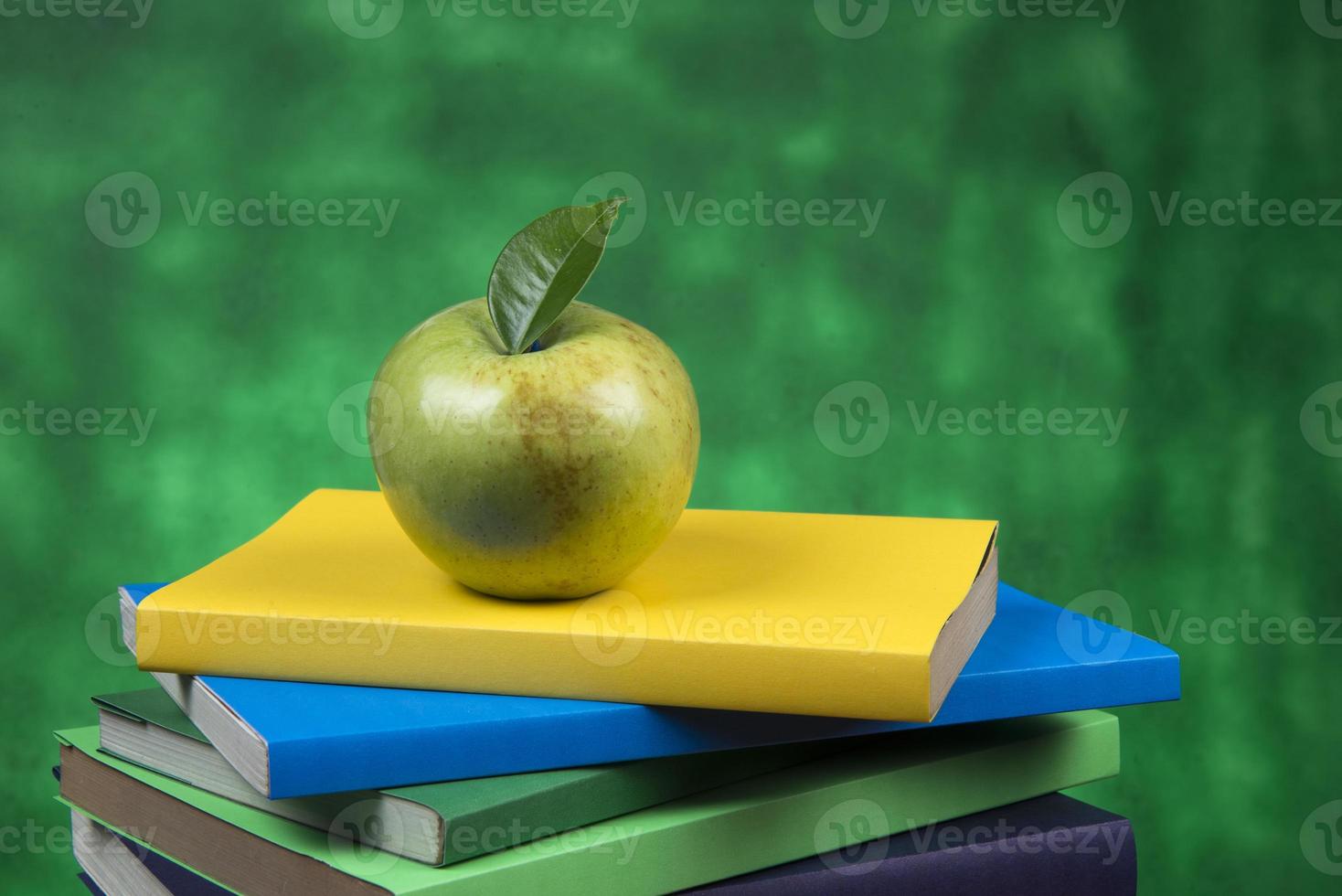 Apple fruit on top of a book stack, on the back of school classes. photo