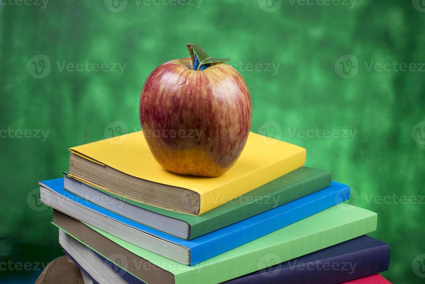 Apple fruit on top of a book stack, on the back of school classes. photo