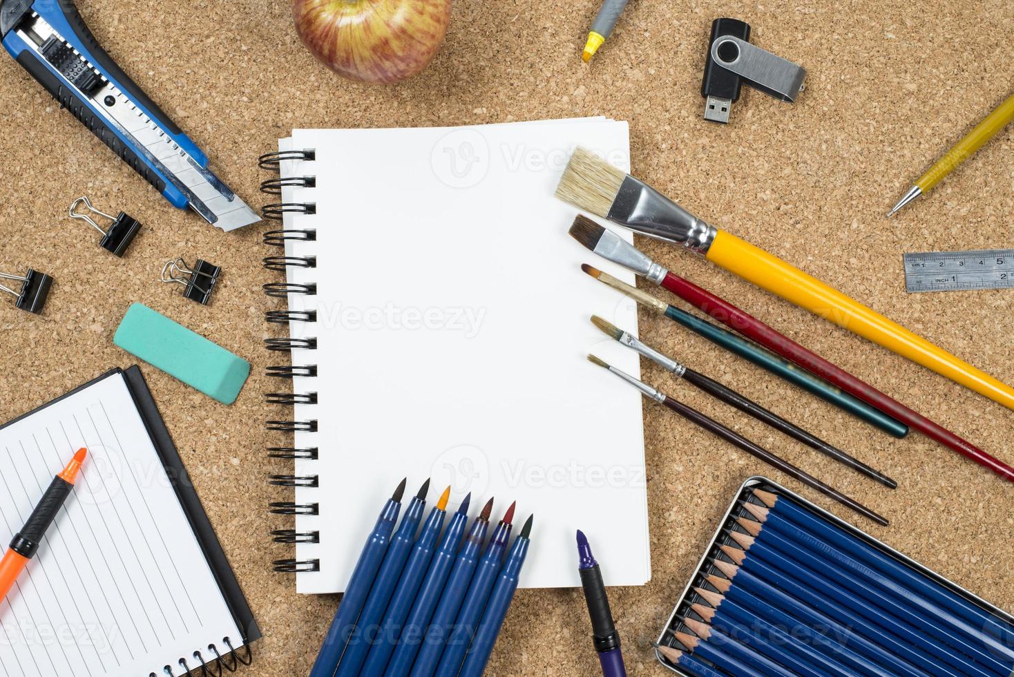 School elements on cork background with space for text symbolizing back to school photo