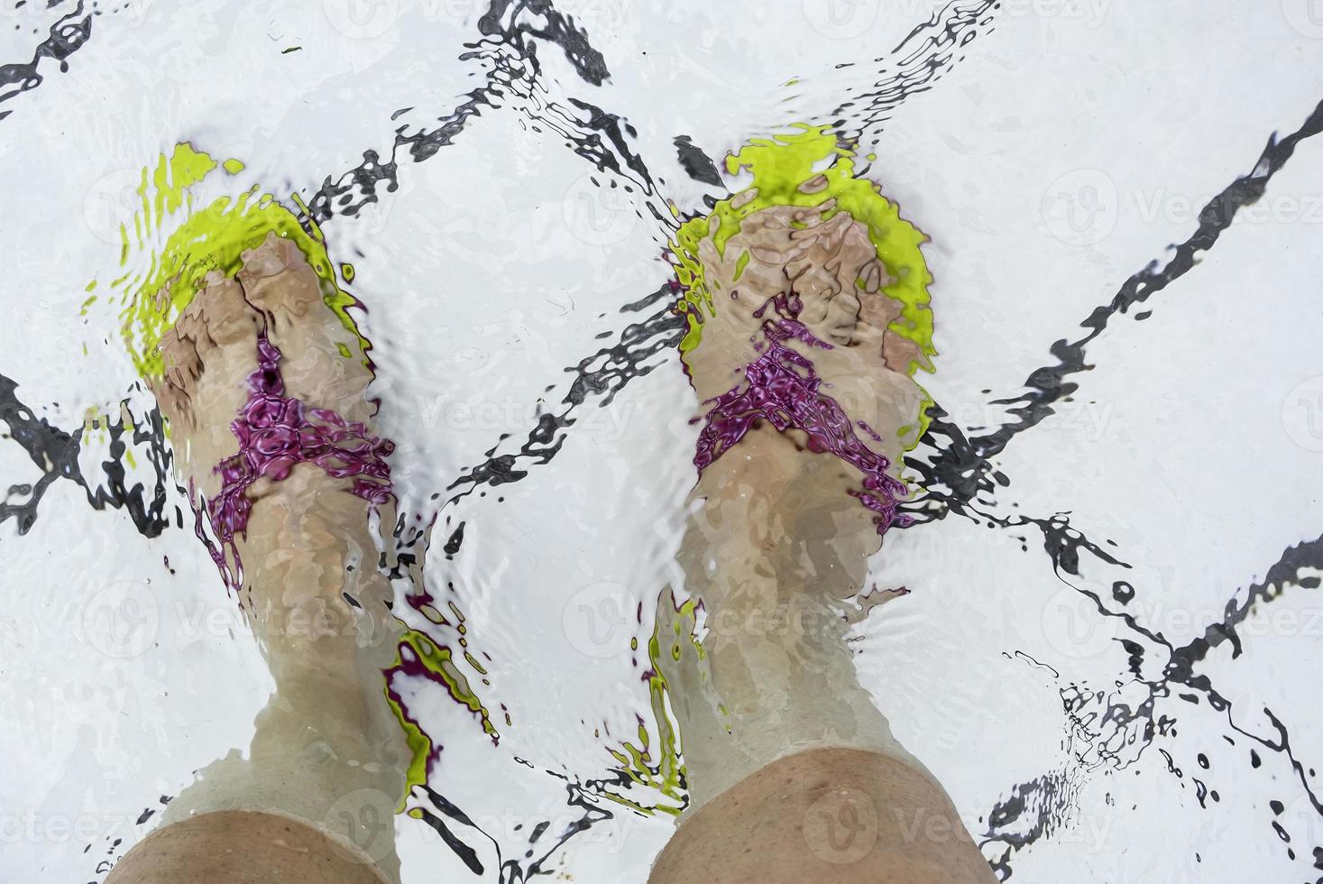 Feet with flip flops in the pool photo