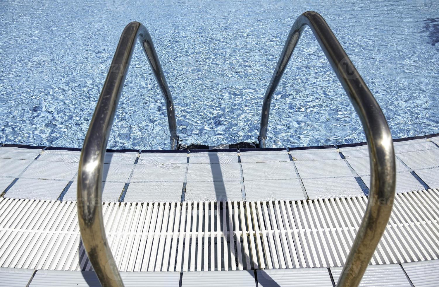 Metal ladder in a swimming pool photo