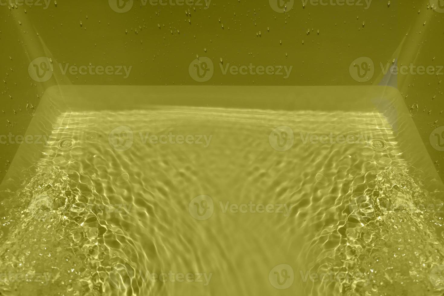 Defocus blurred transparent yellow colored clear calm water surface texture with splashes and bubble. Trendy abstract nature background. Water wave in sunlight with copy space. Yellow water shining. photo
