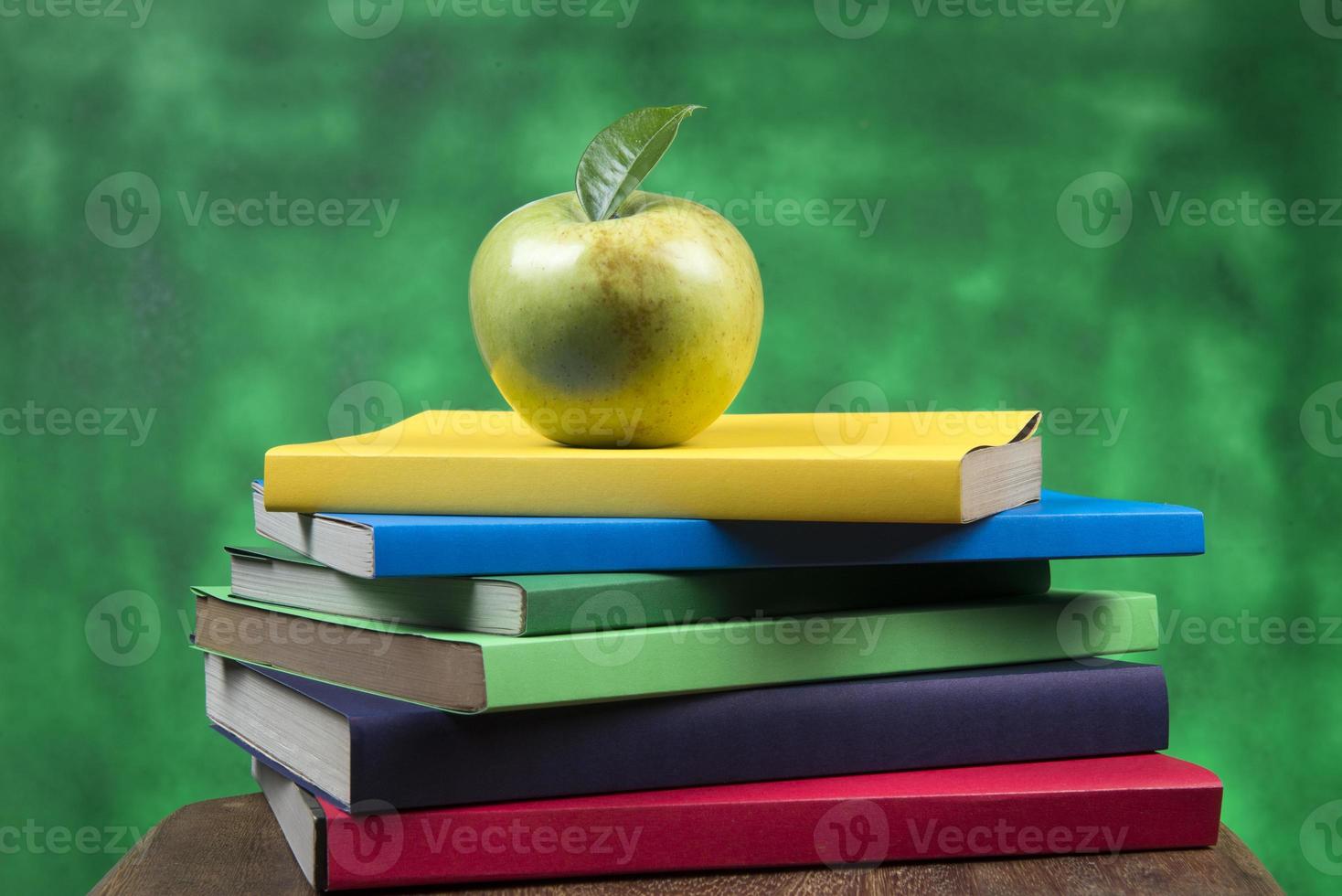 Apple fruit on top of a book stack, on the back of school classes. photo