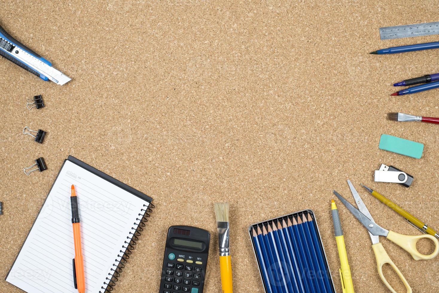 elementos escolares sobre fondo de corcho con espacio para texto que simboliza el regreso a la escuela foto