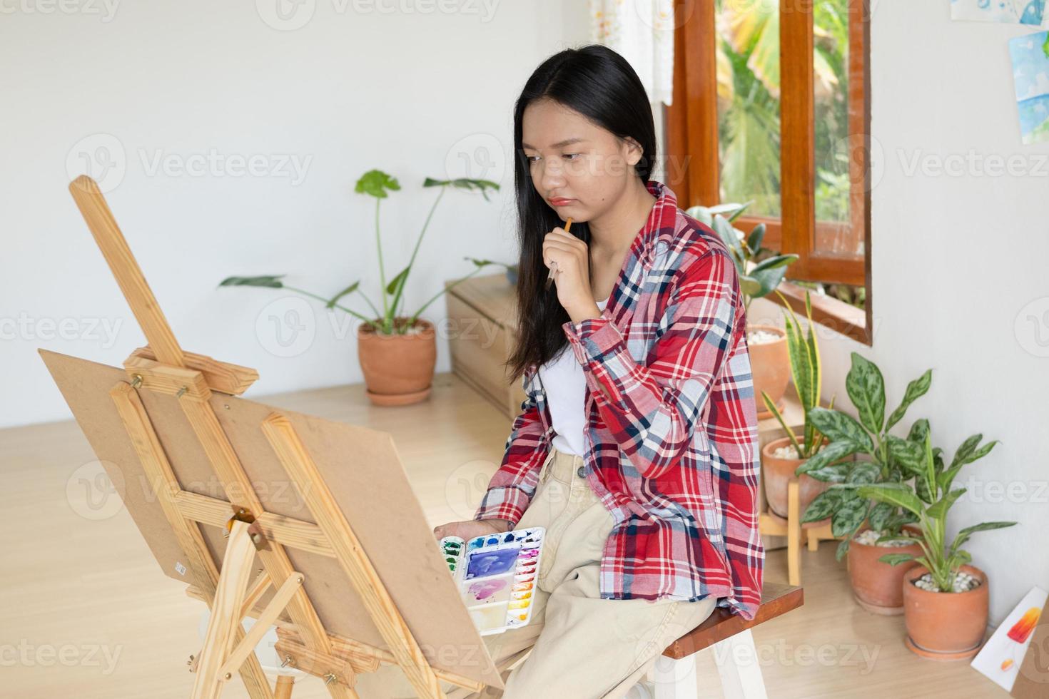 Young girl painting on paper at home, wood frame,Hobby and art study at home. photo