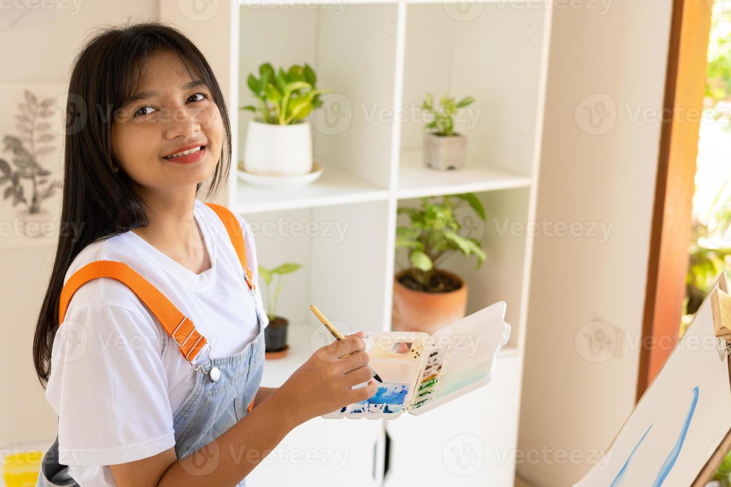 niña pintando en papel en casa, marco de madera, hobby y estudio de arte en casa. foto