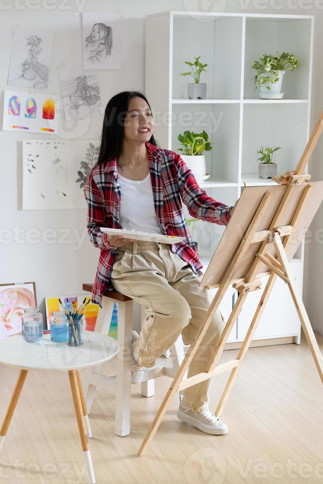 Young girl painting on paper at home, wood frame,Hobby and art study at home. photo