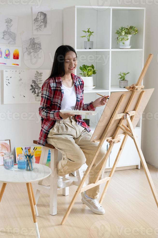 Young girl painting on paper at home, wood frame,Hobby and art study at home. photo