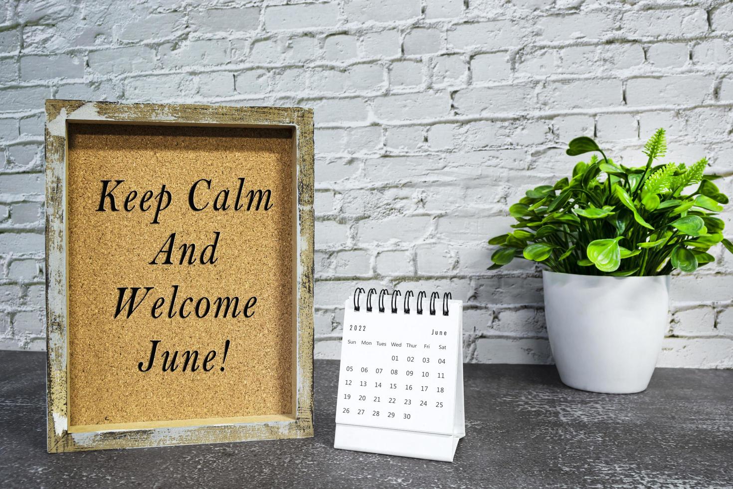 Motivational and inspirational quote on wooden frame with June 2022 calendar. photo