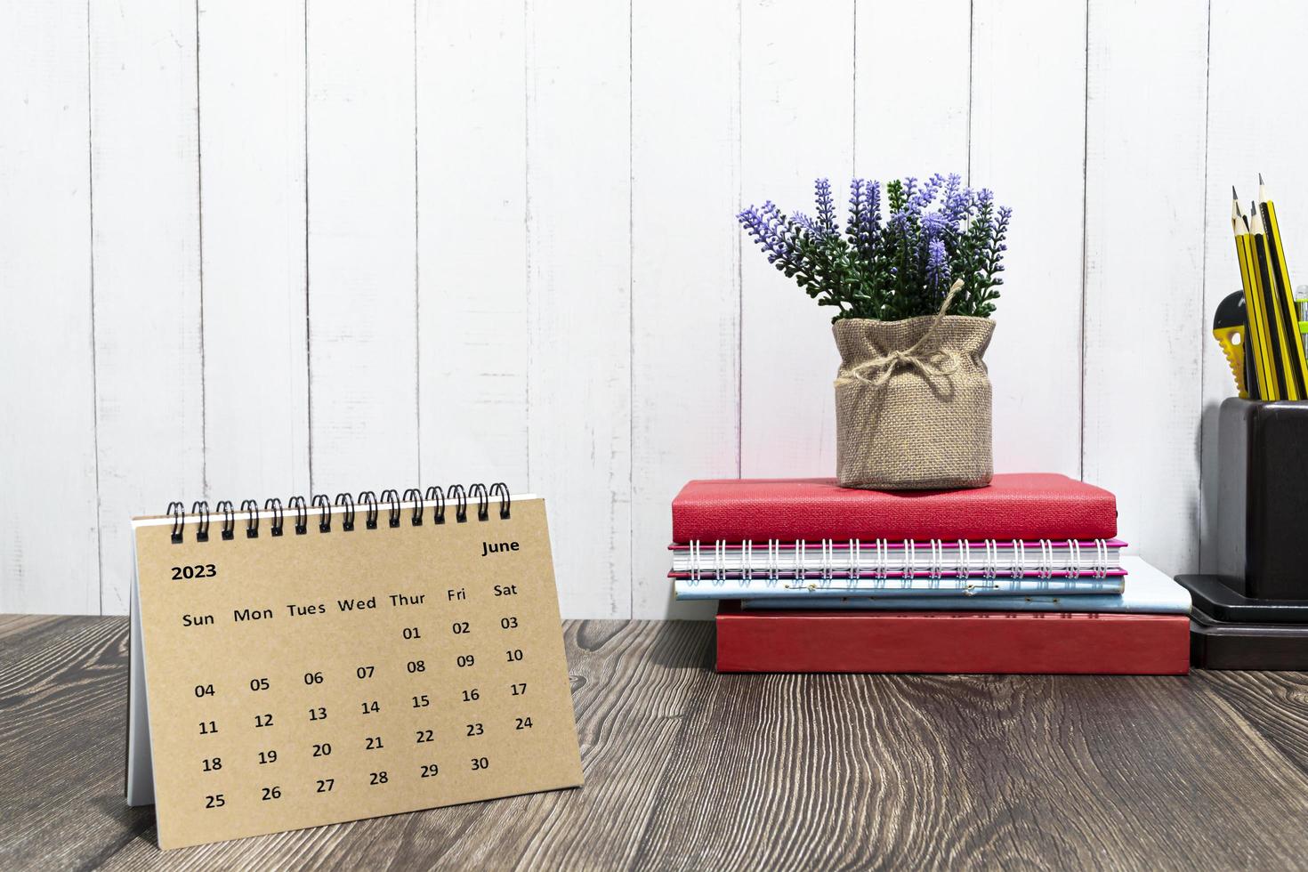 Brown June calendar 2023 calendar on wooden desk with office stationery. photo