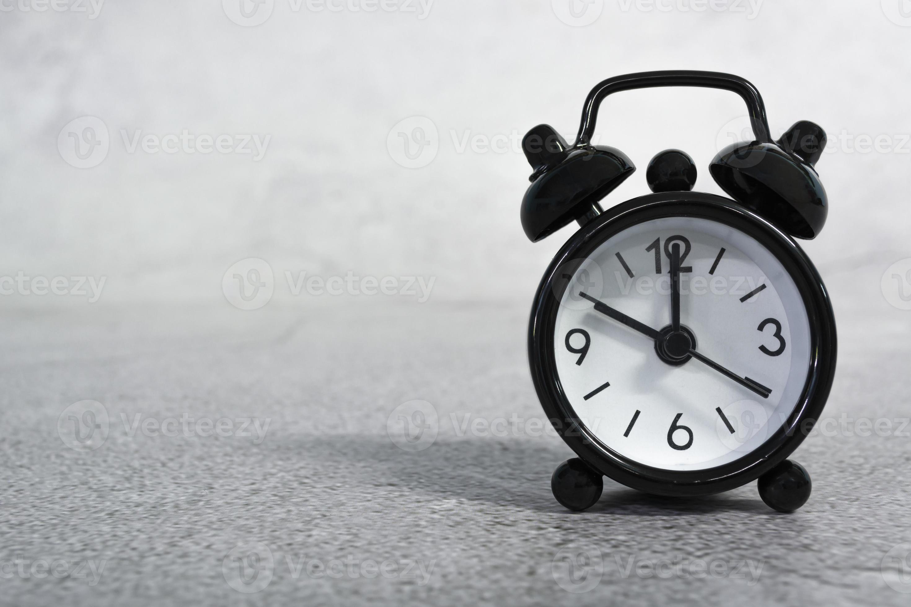 Black alarm clock isolated. The clock set at 10 o'clock. Deadline