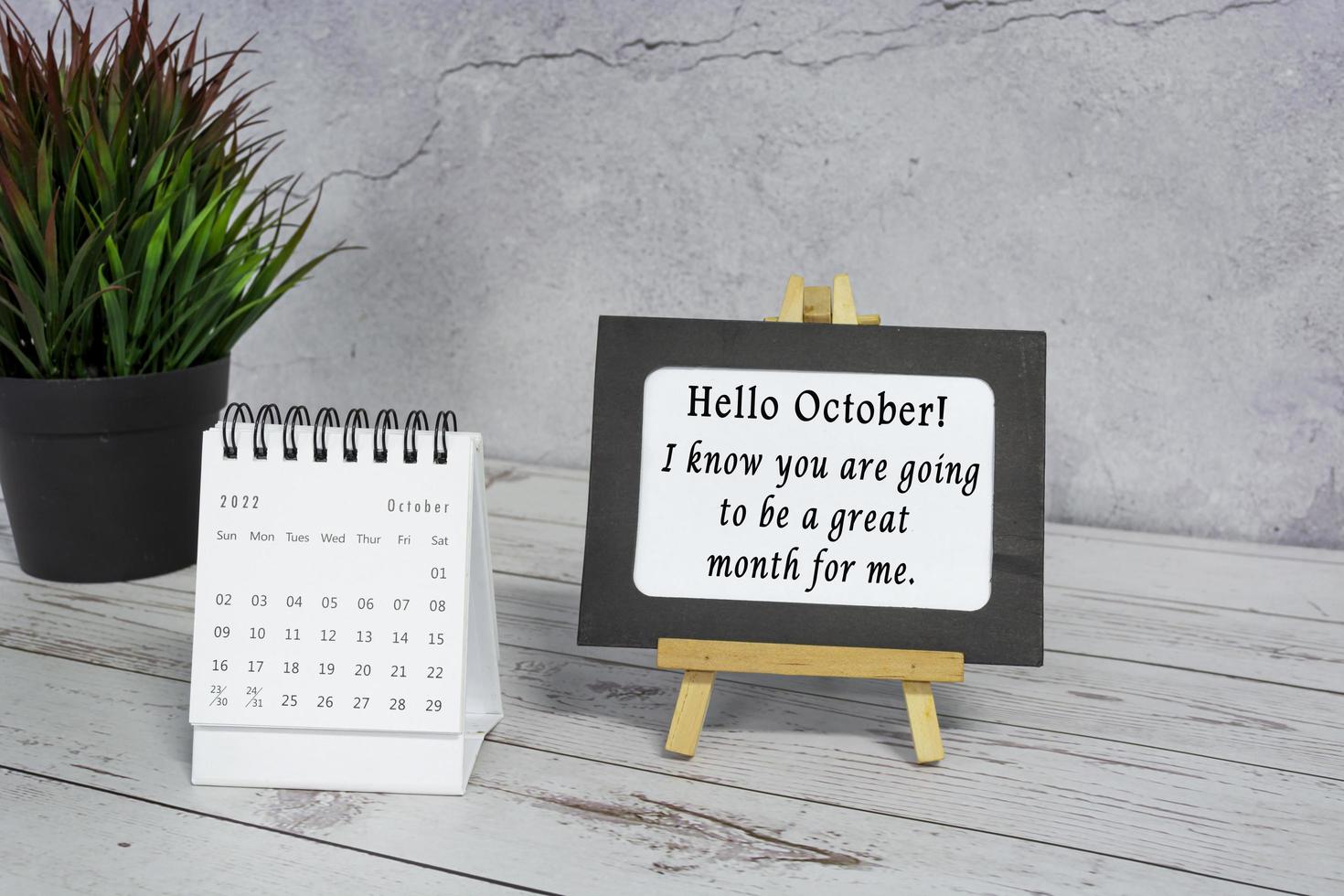 Motivational quotes on paper frame with October 2022 calendar . photo